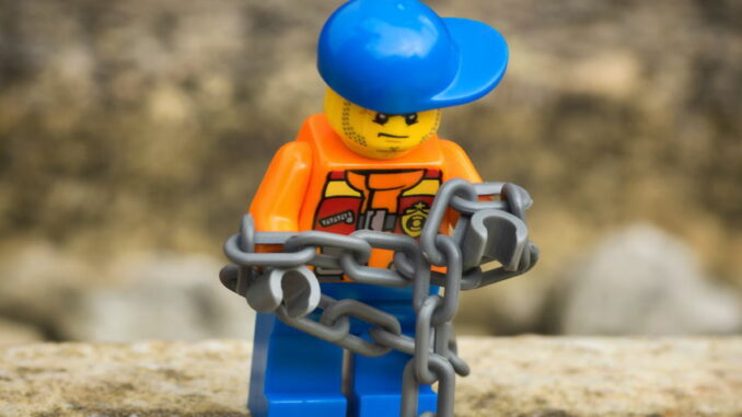 Lego figure in chains - Unsplash