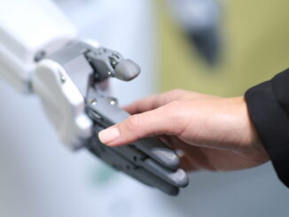 A person shaking hands with a robot - Source HSMAI