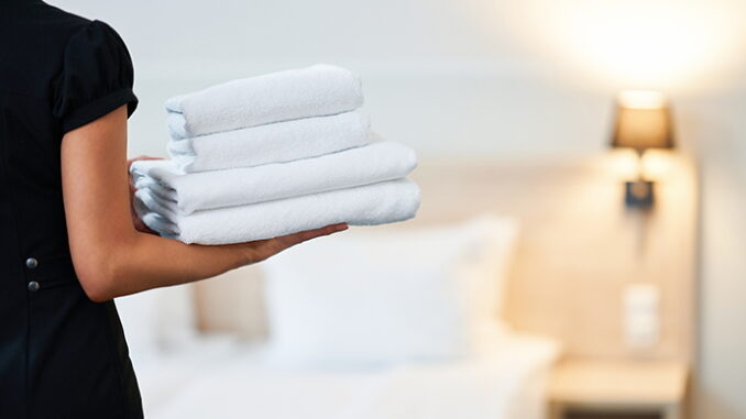 A room attendant holding towels